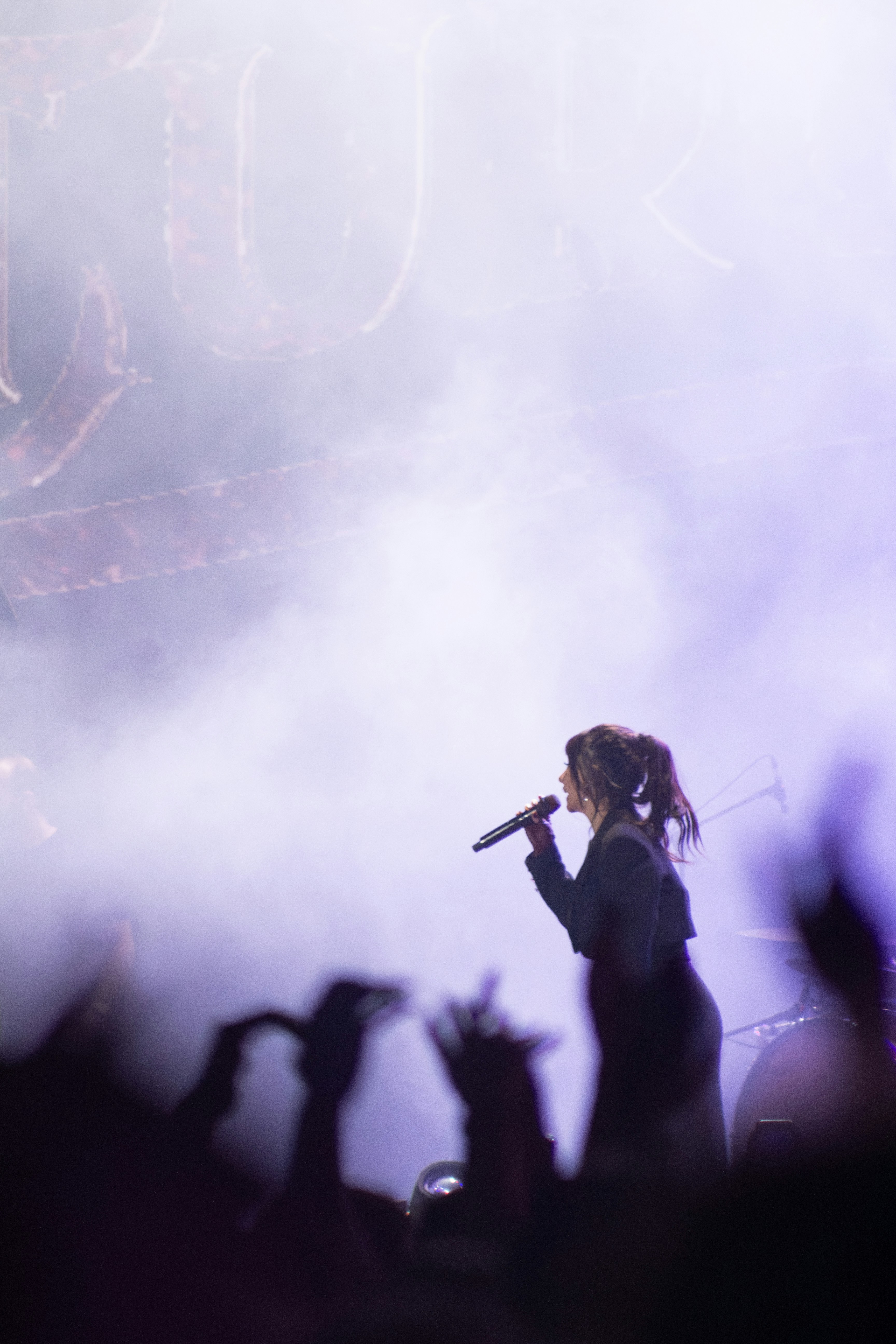 Worship leader on stage with atmospheric purple lighting