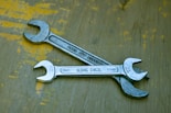 A wrench sitting on top of a wooden table