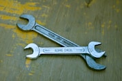 A wrench sitting on top of a wooden table