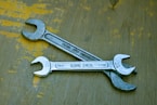 A wrench sitting on top of a wooden table