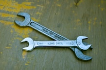 A wrench sitting on top of a wooden table