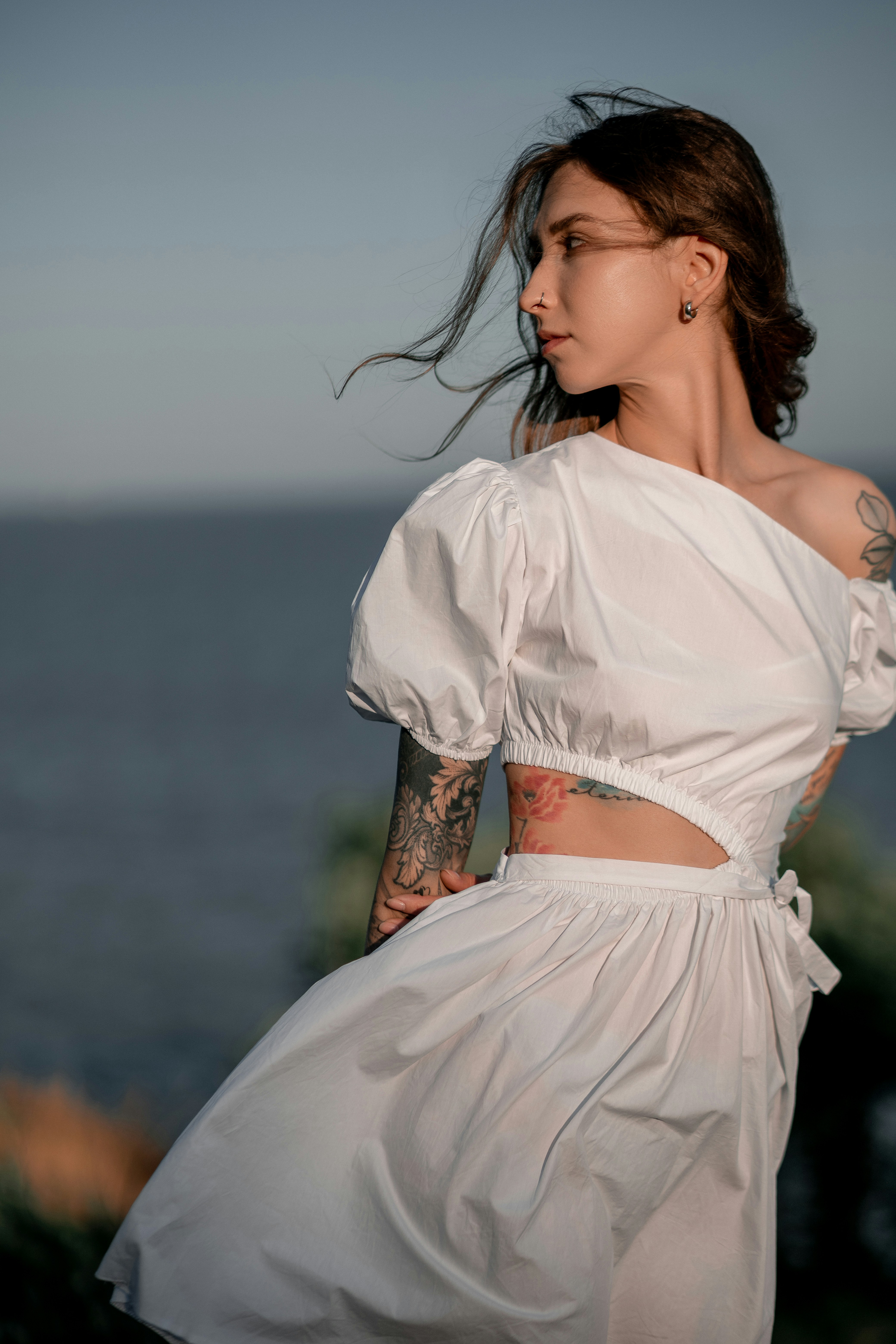 Eine Frau in einem weißen Kleid steht in der Nähe des Ozeans