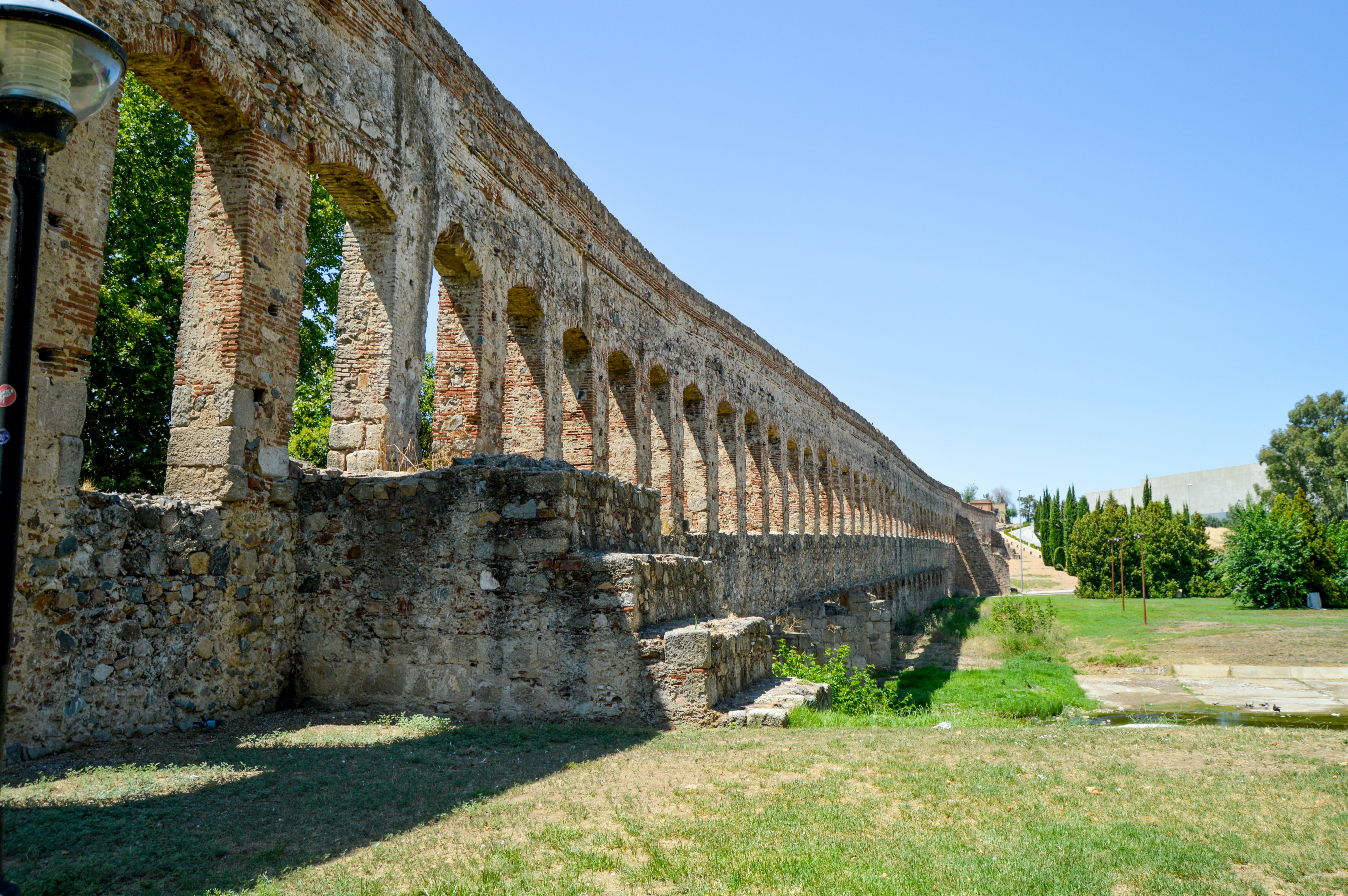 A man standing next to a stone wall