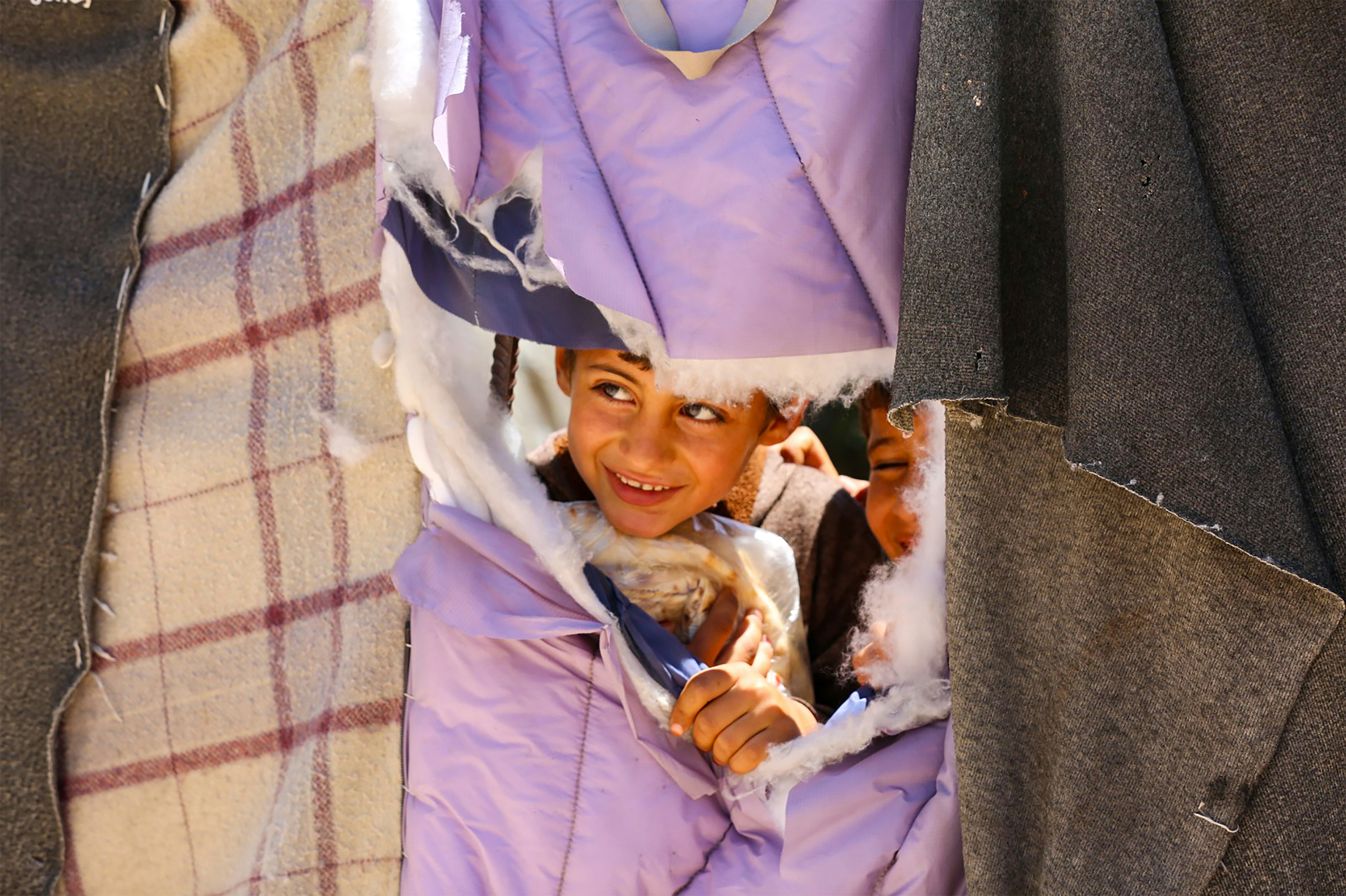 A little girl is laying in a pile of clothes