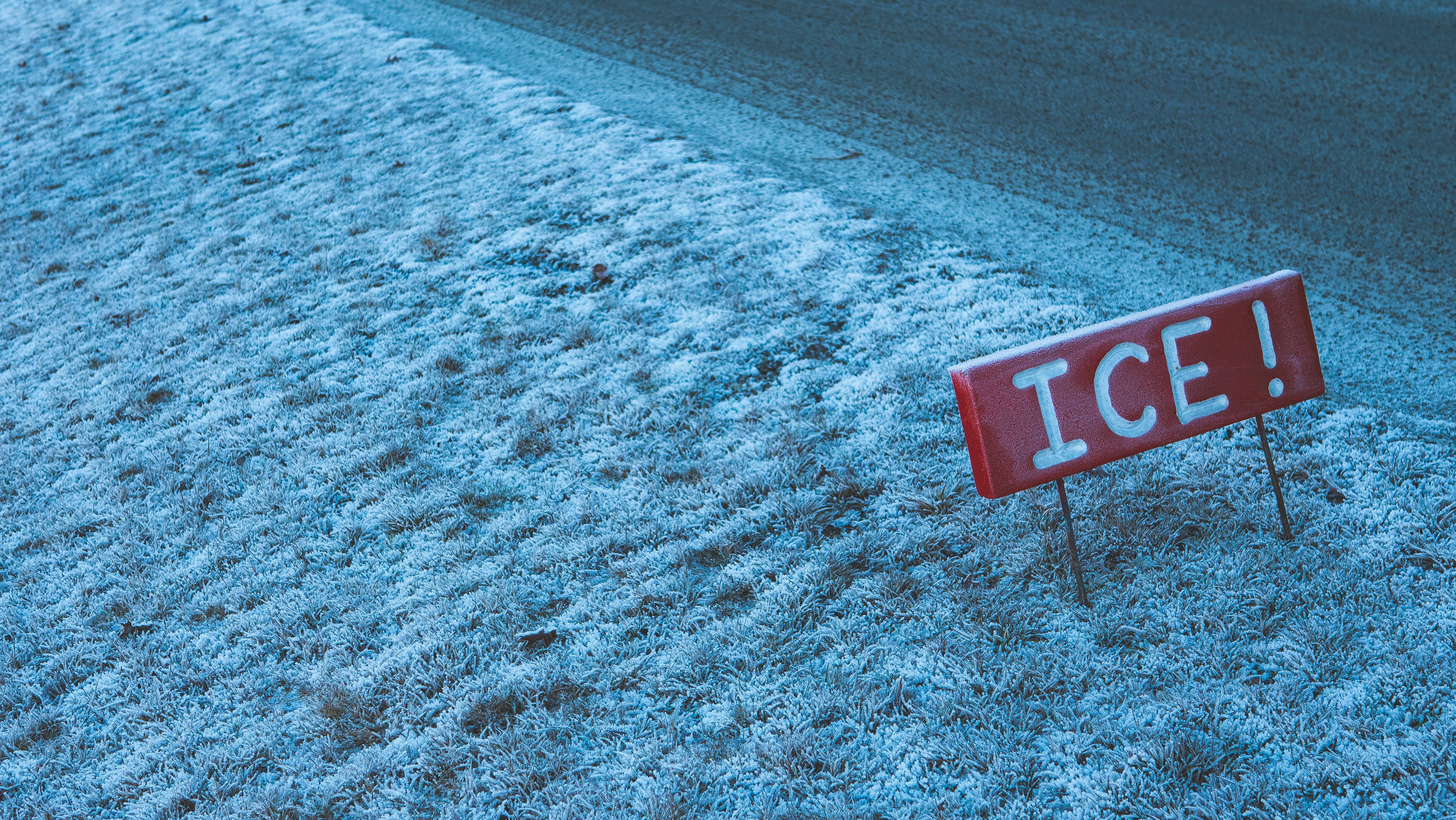 A red ice sign sitting on the side of a road