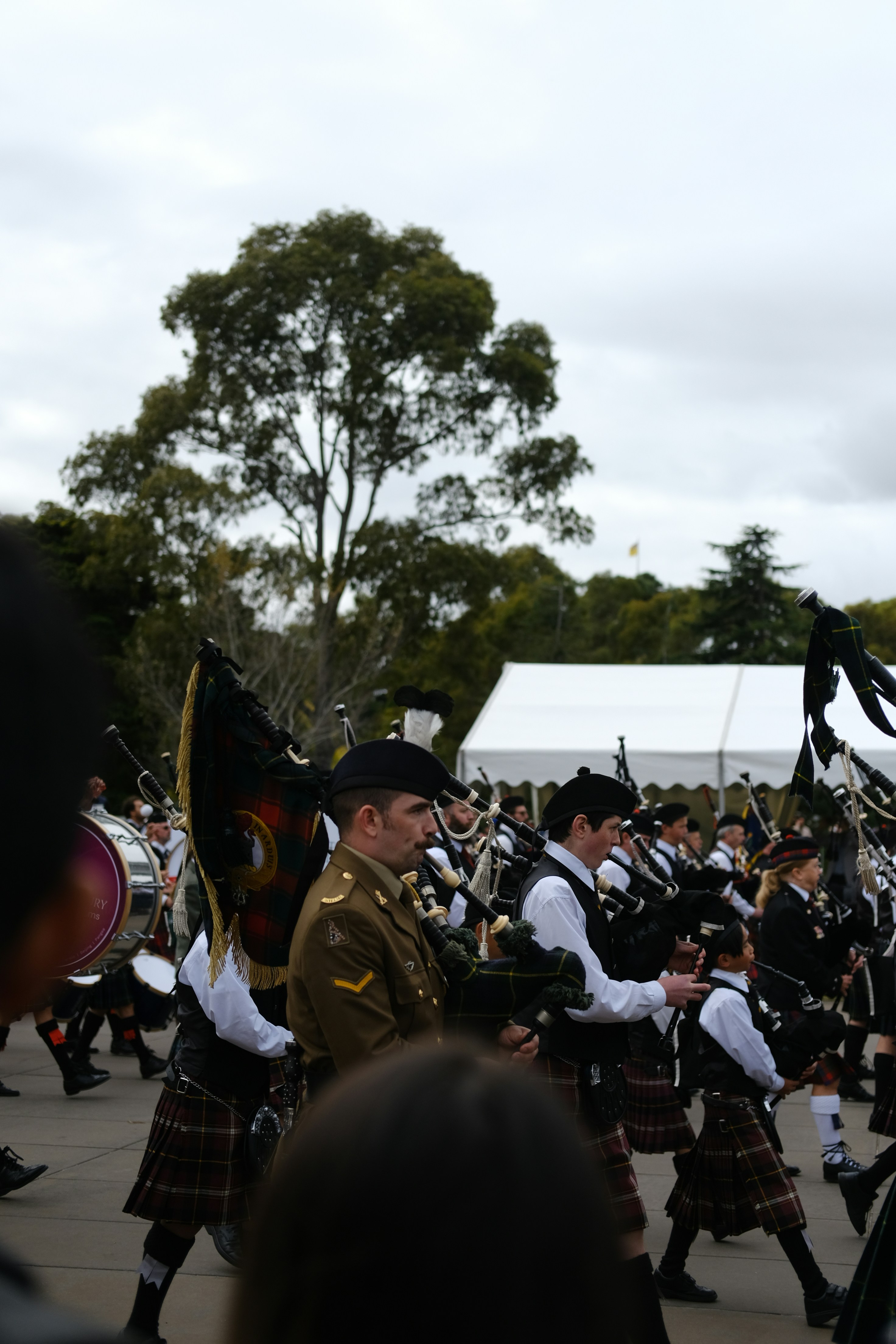 A group of men in kilts marching down a street
