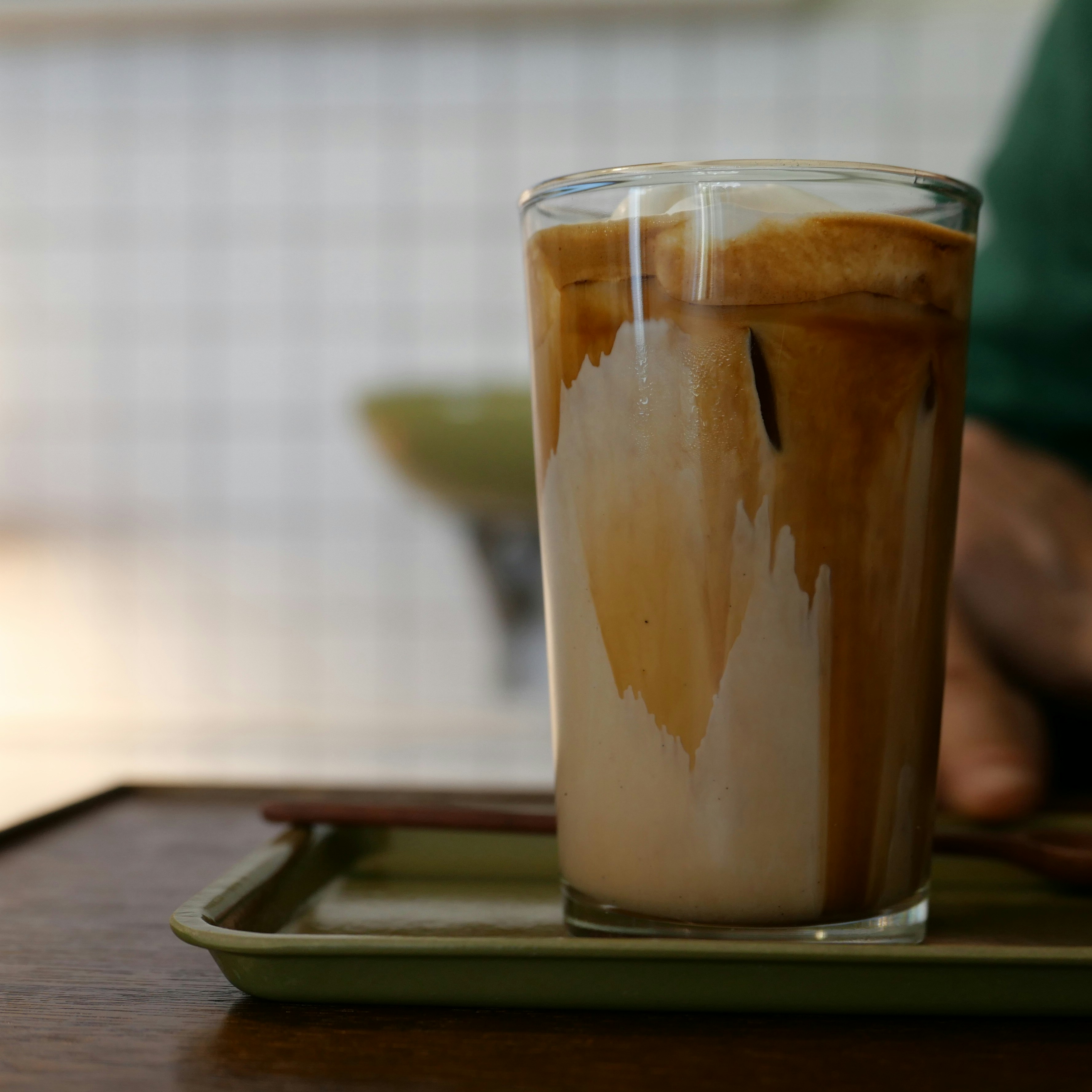 A glass of coffee sitting on top of a wooden table