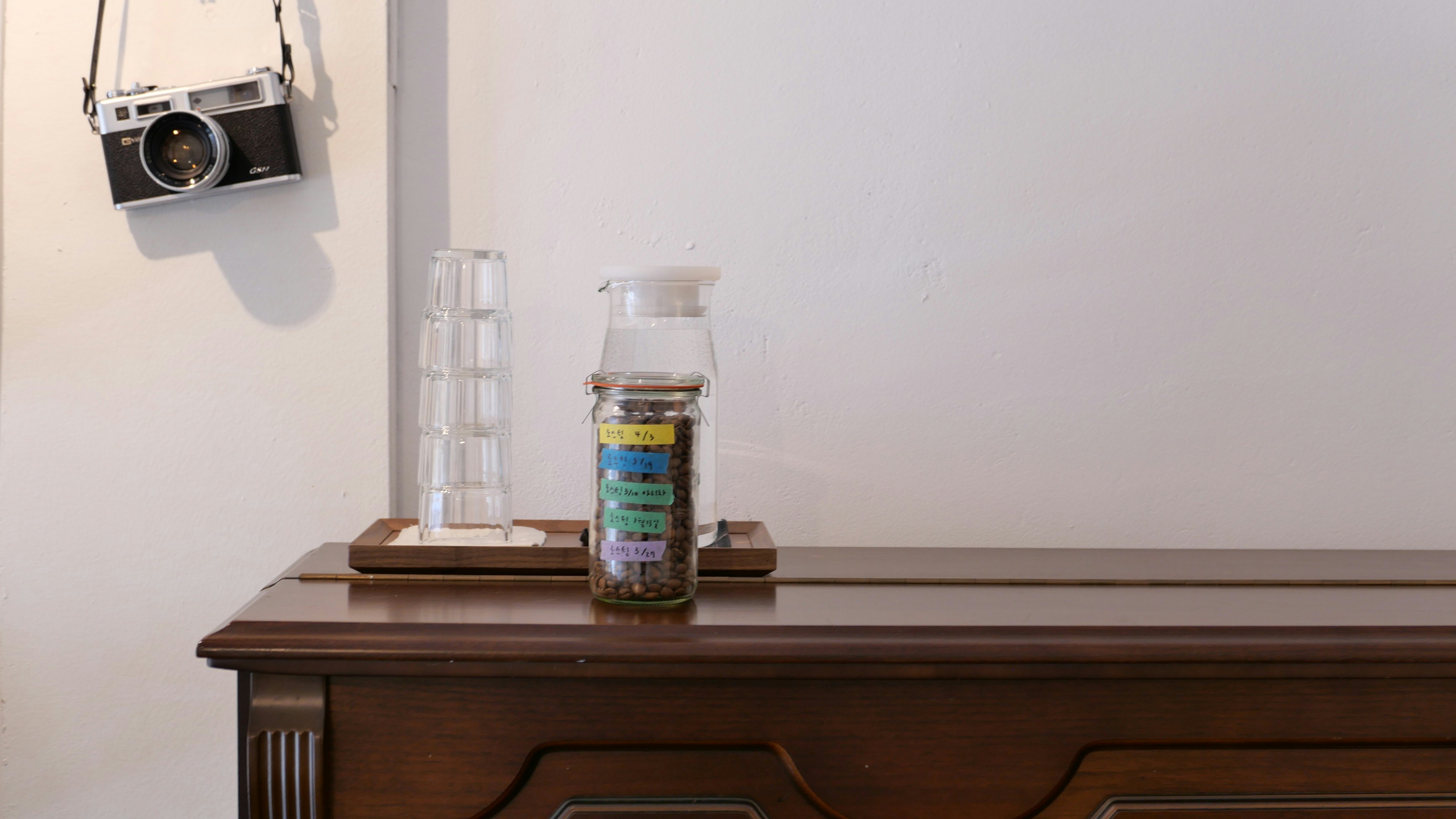 A camera hanging on a wall next to a dresser