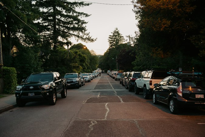 A quiet residential street with parked cars, illustrating a neighborhood level housing market