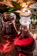 A table topped with two vases filled with liquid
