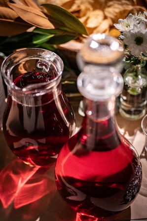 A table topped with two vases filled with liquid
