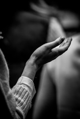 A black and white photo of a person holding their hands together