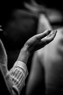 A black and white photo of a person holding their hands together