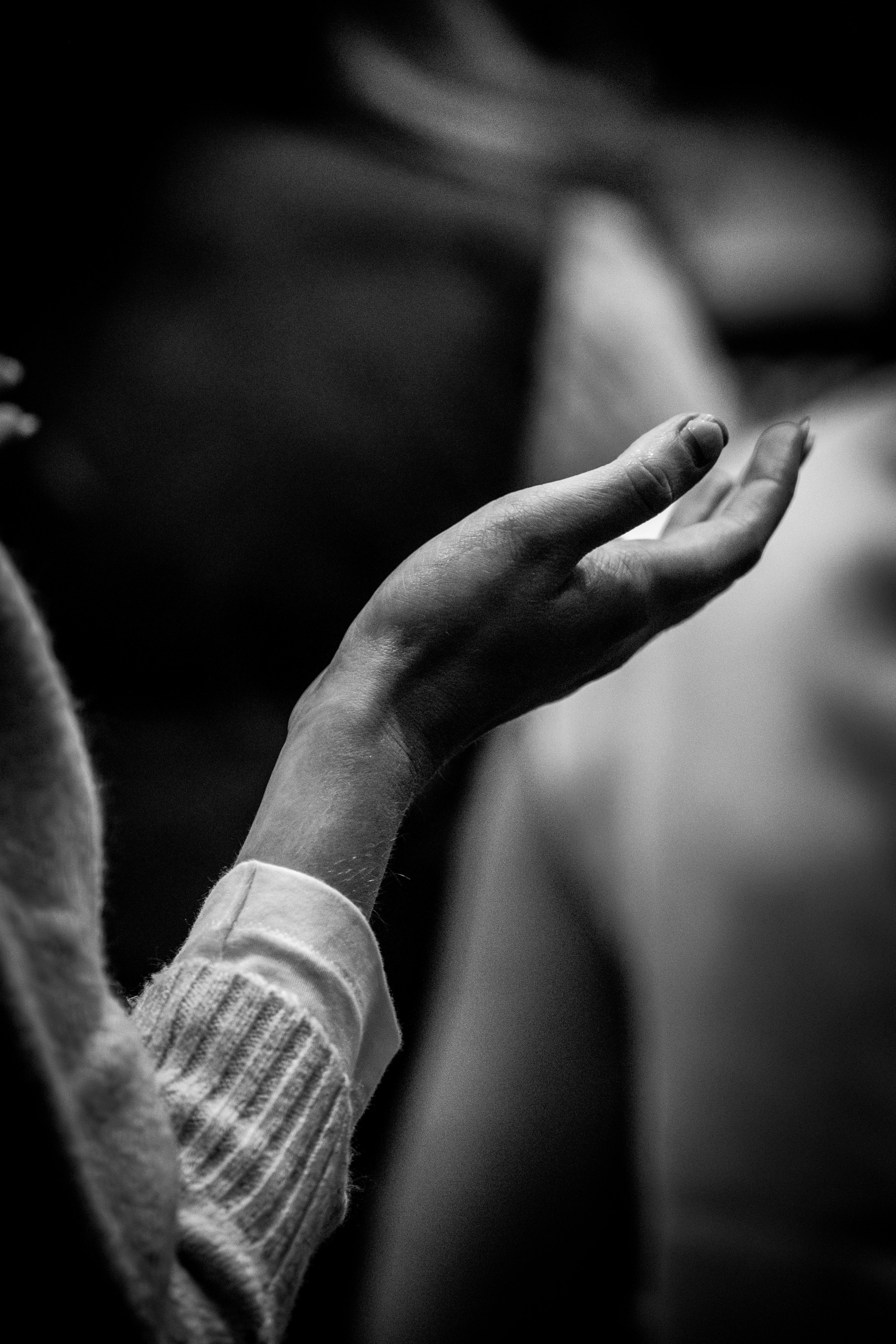 A black and white photo of a person holding their hands together