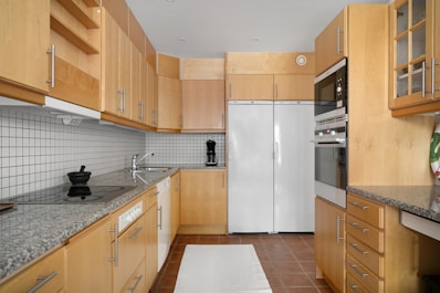 A kitchen with wooden cabinets and white appliances