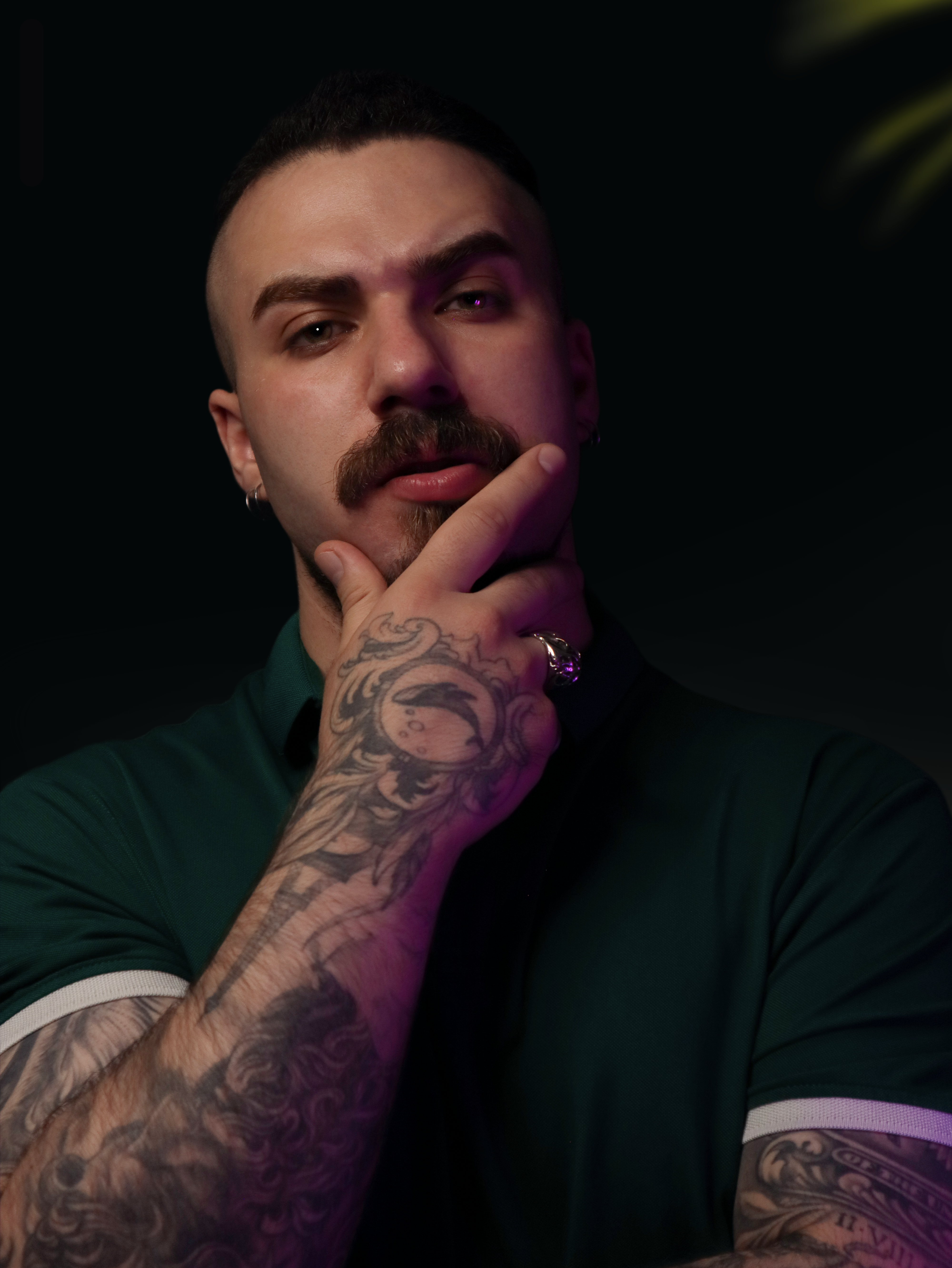 A man with tattoos and a ring on his finger