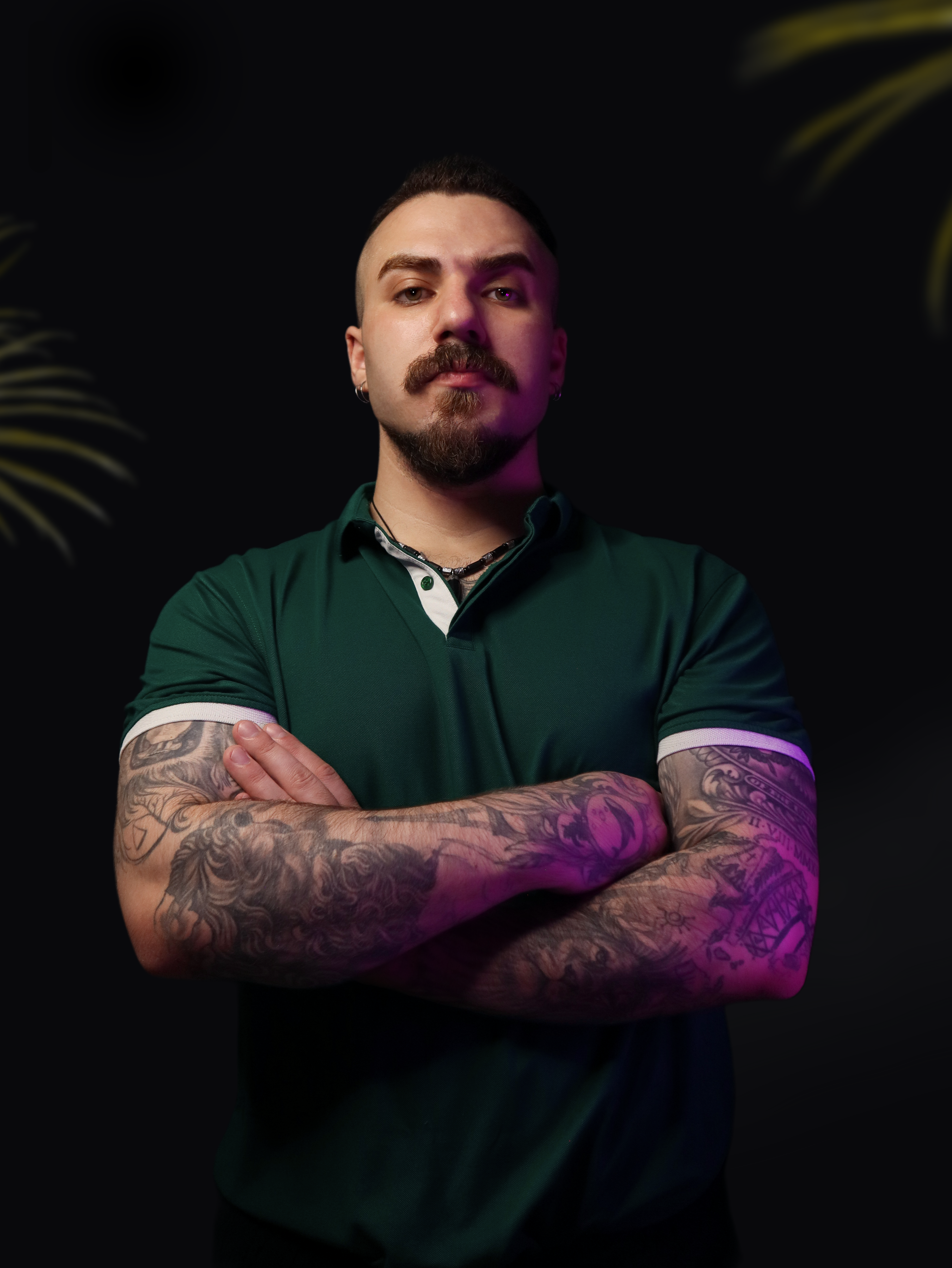 A man with tattoos standing with his arms crossed