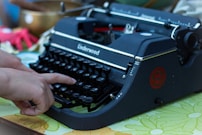 A person typing on an old fashioned typewriter