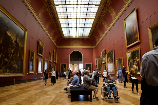 Bezoekers in een museumzaal vol schilderijen