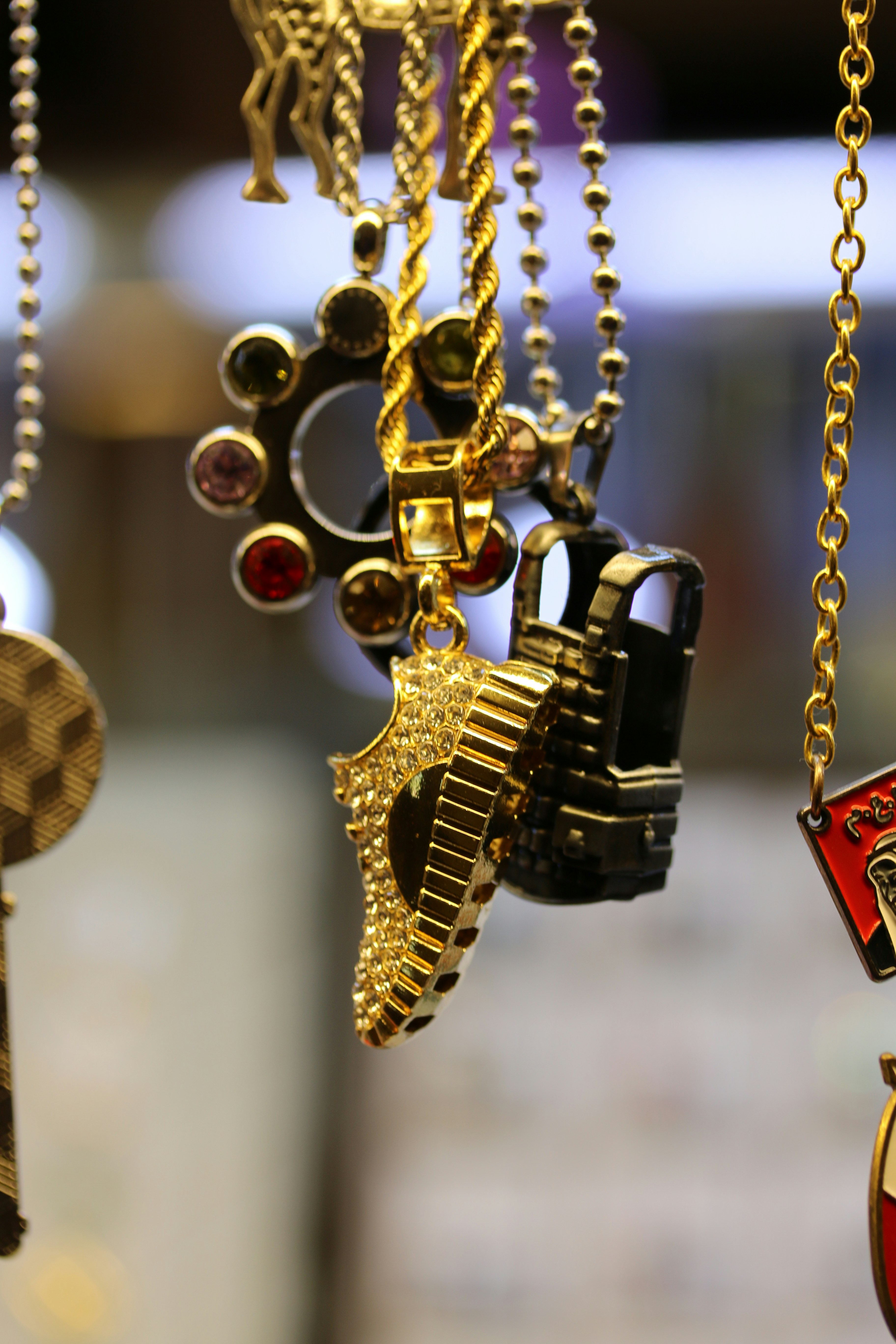 A close up of a bunch of necklaces hanging from chains