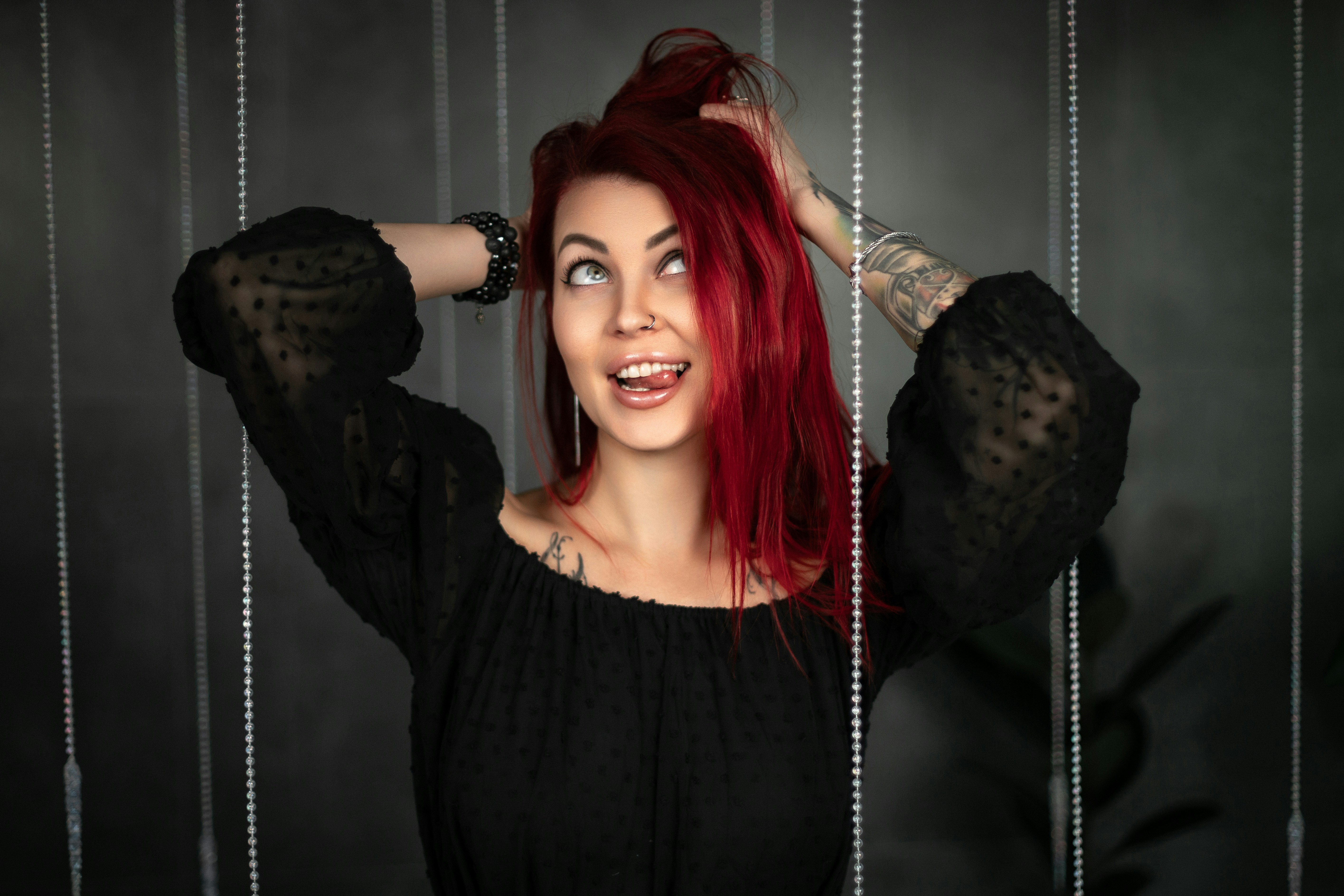 A woman with red hair standing behind bars