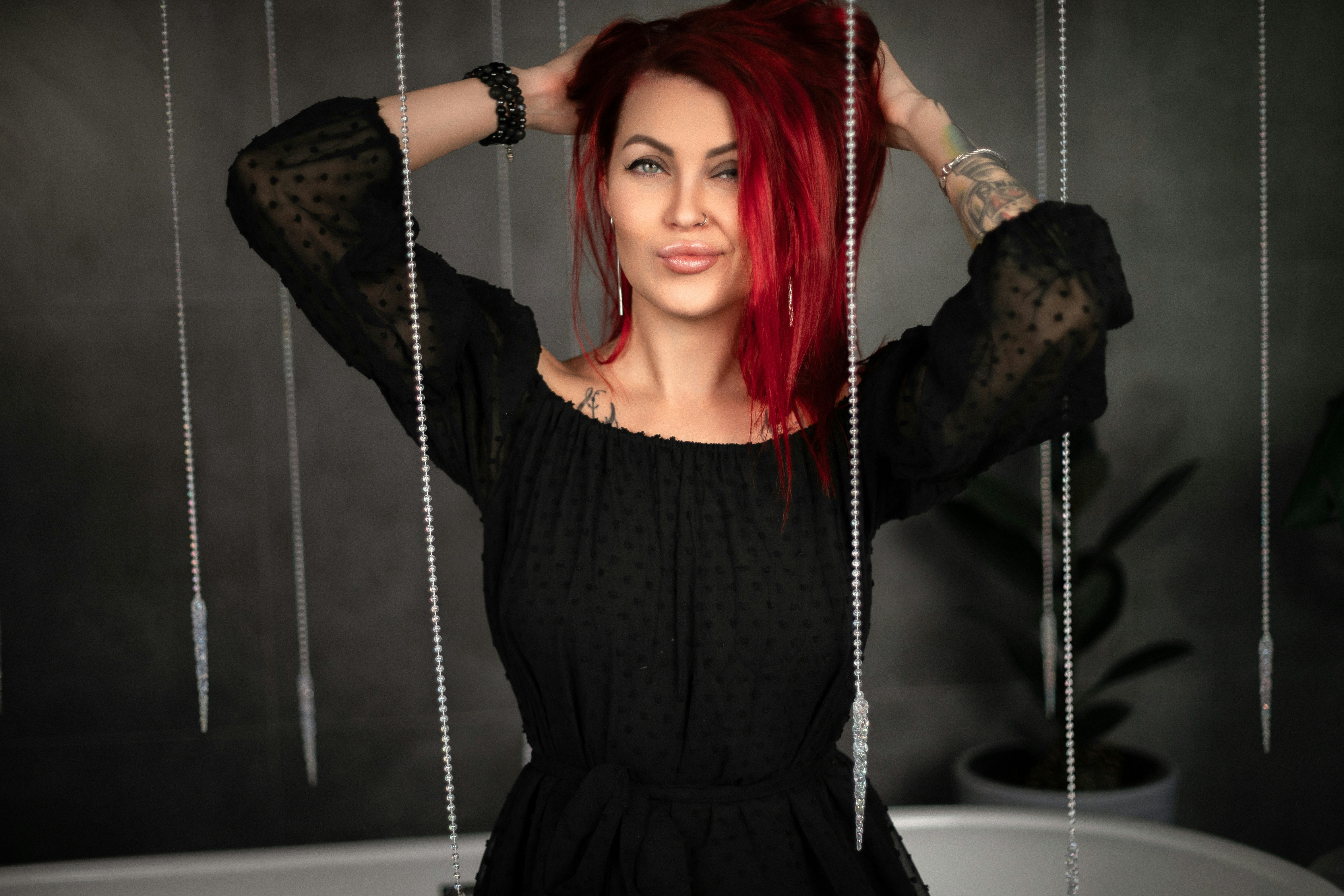 A woman with red hair standing in front of a tub