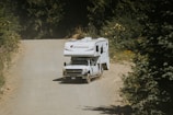 A truck pulling a trailer down a dirt road
