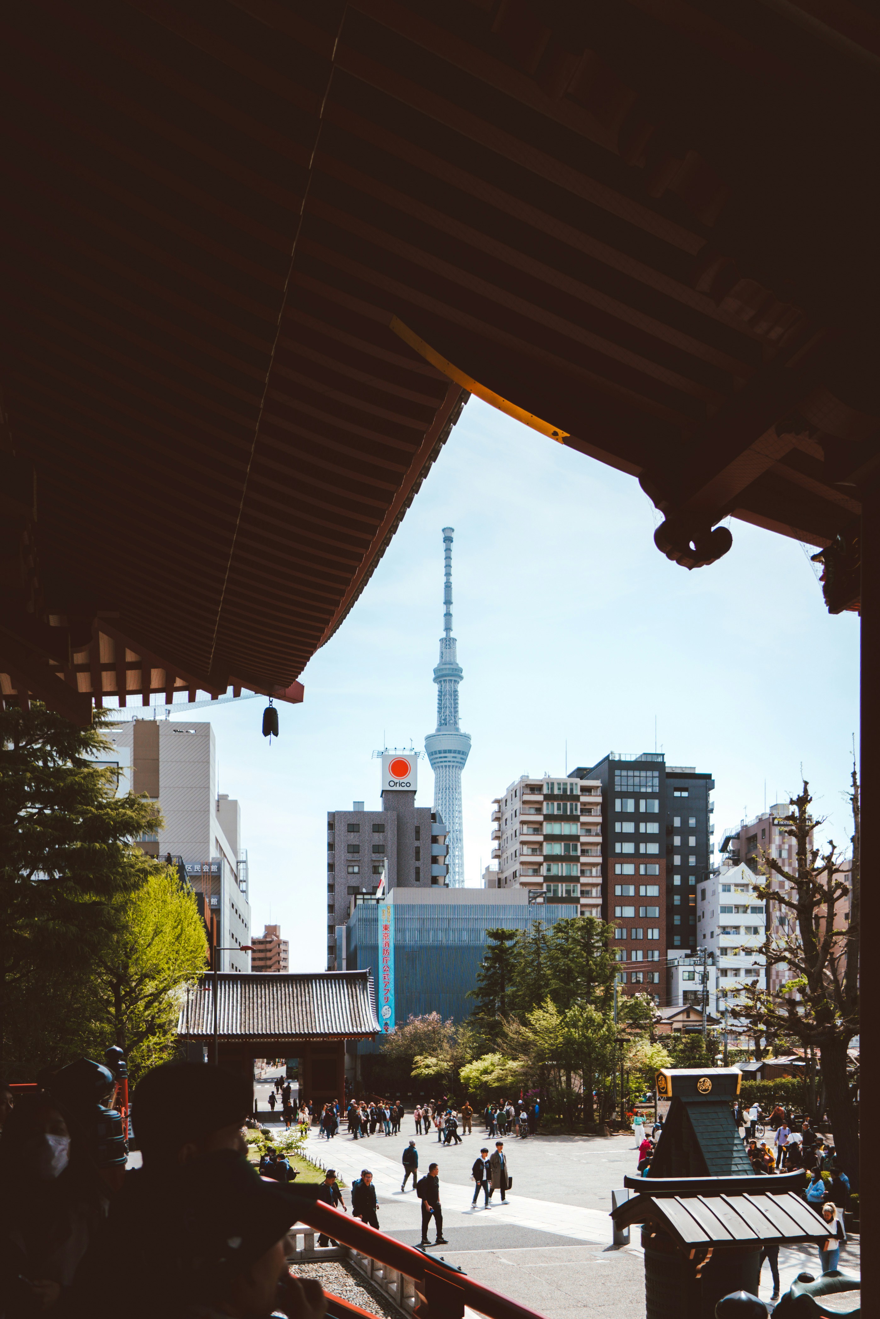 A group of people walking down a street next to tall buildings