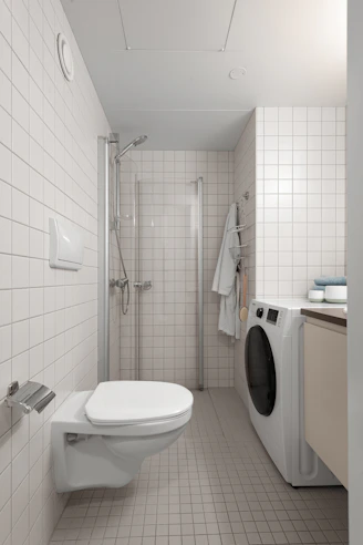 A bathroom with a toilet, washer and dryer