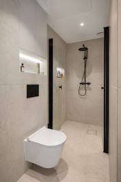 A white toilet sitting in a bathroom next to a shower