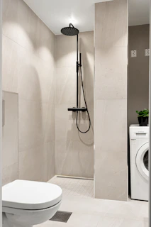 A white toilet sitting next to a washer and dryer