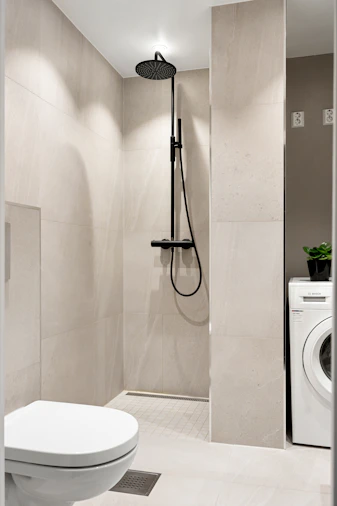 A white toilet sitting next to a washer and dryer