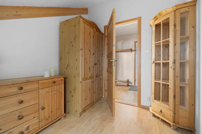 A room with wooden furniture and white walls
