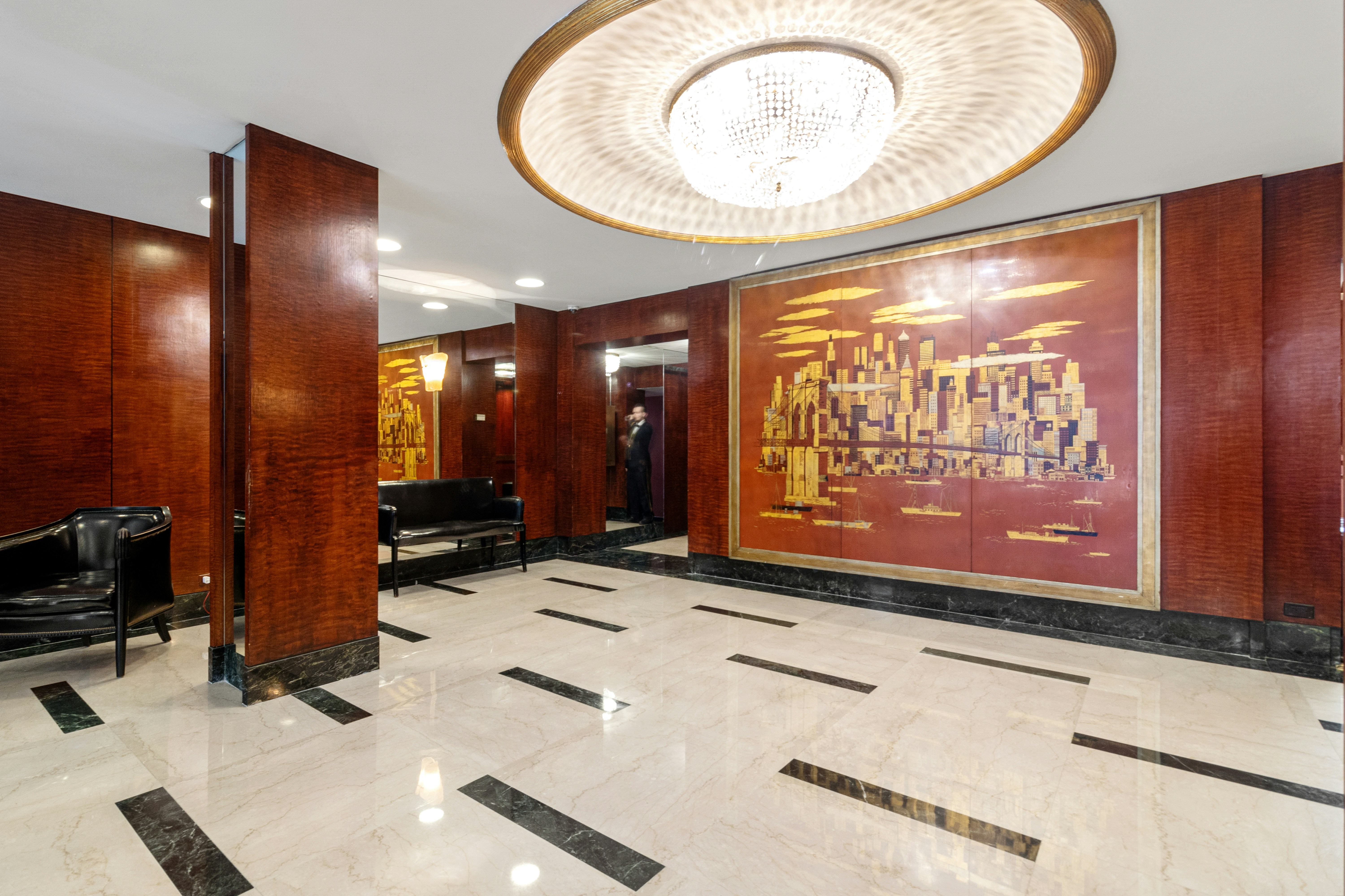A lobby with a piano and a large painting on the wall