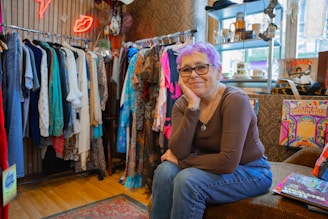 A woman sitting on a bench in a clothing store