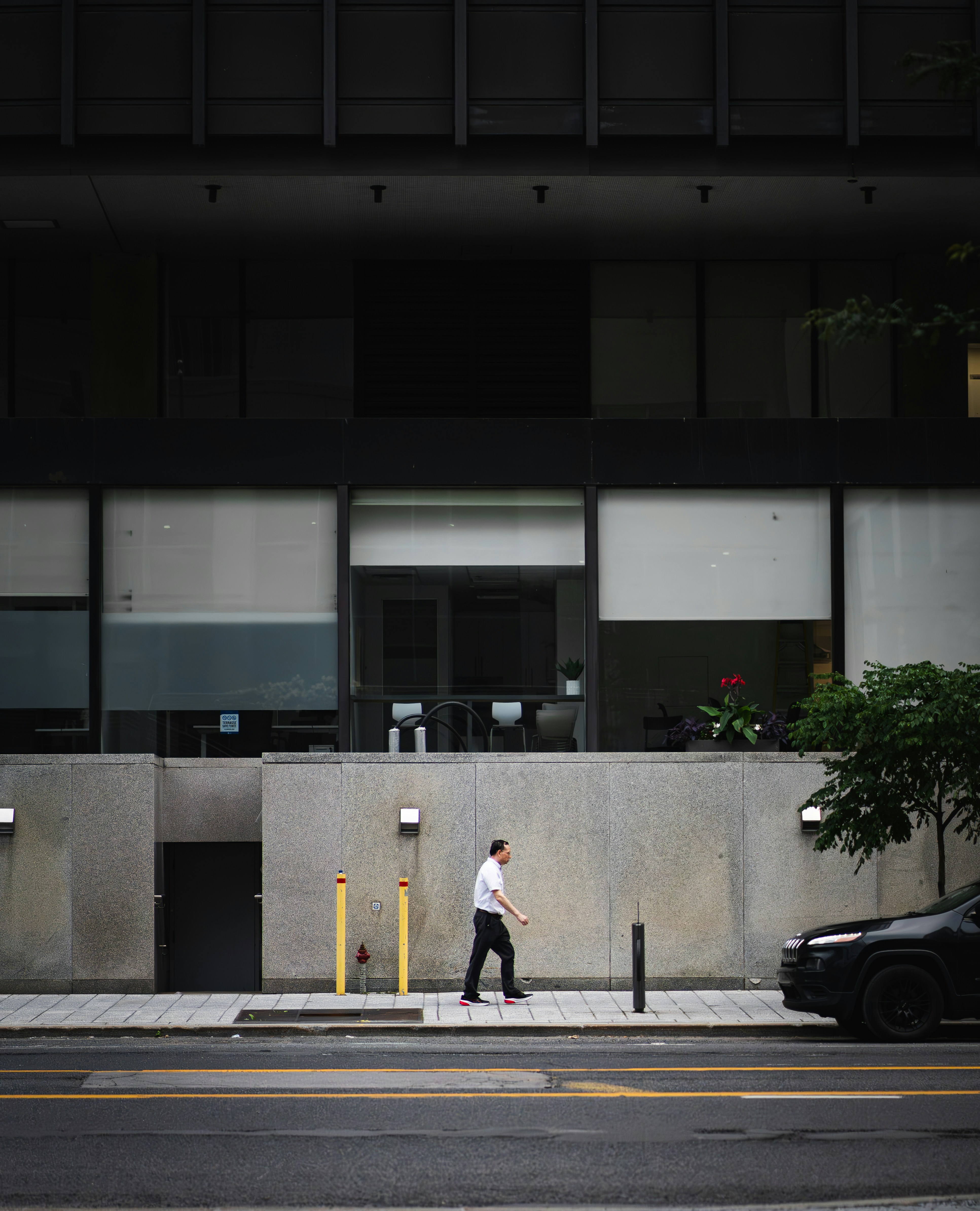 A man walking down a street next to a tall building