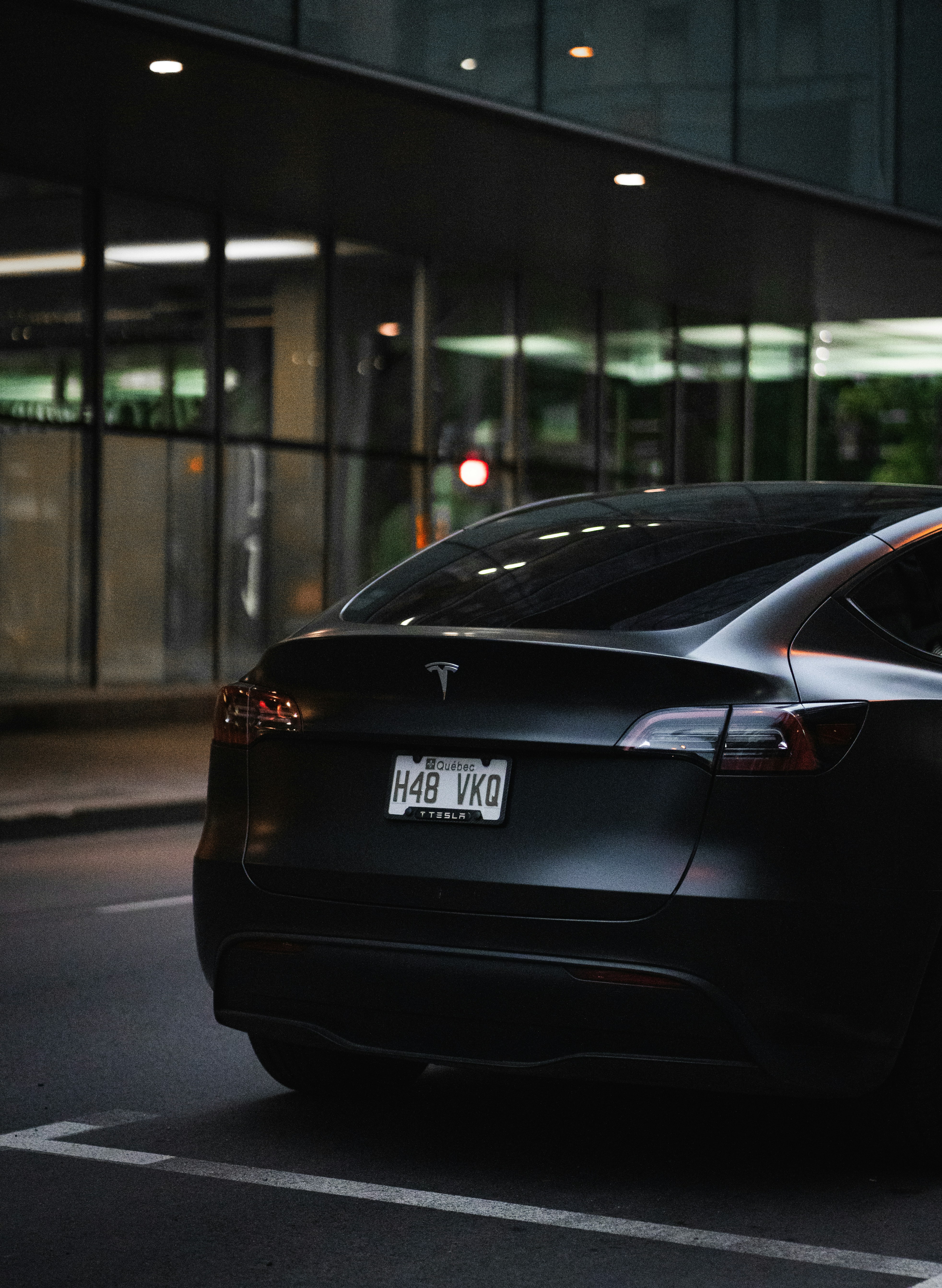 A black tesla parked on the side of the road