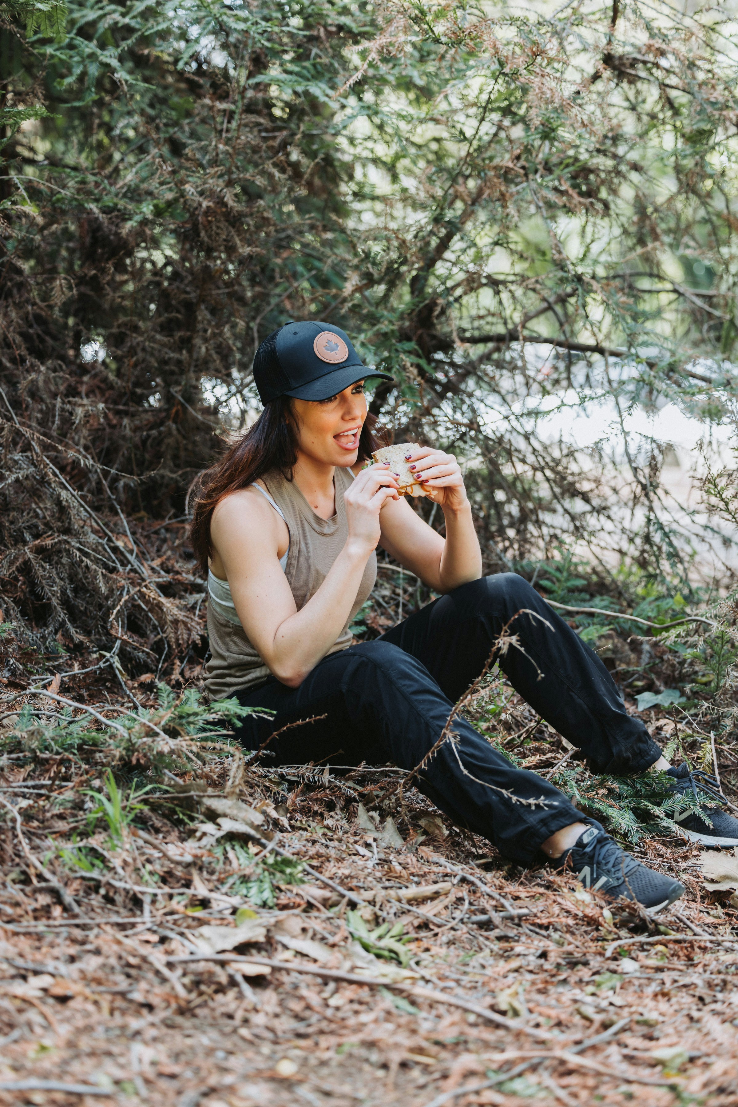 A woman sitting on the ground in the woods