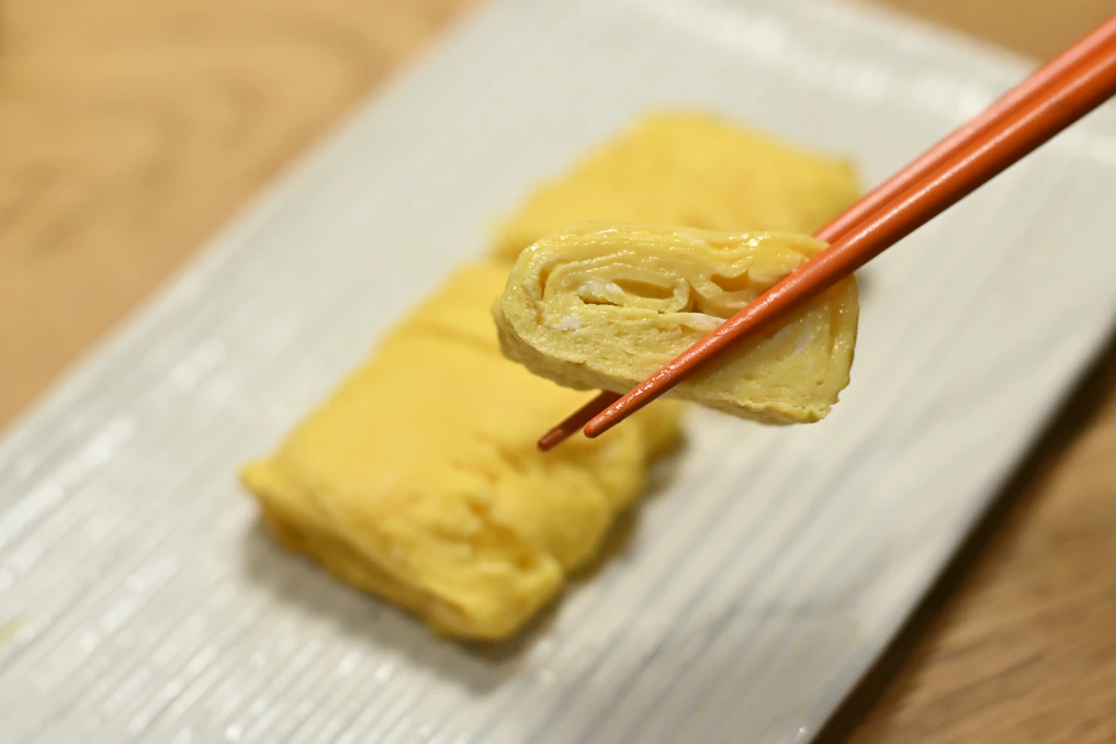 A piece of food on a napkin with chopsticks