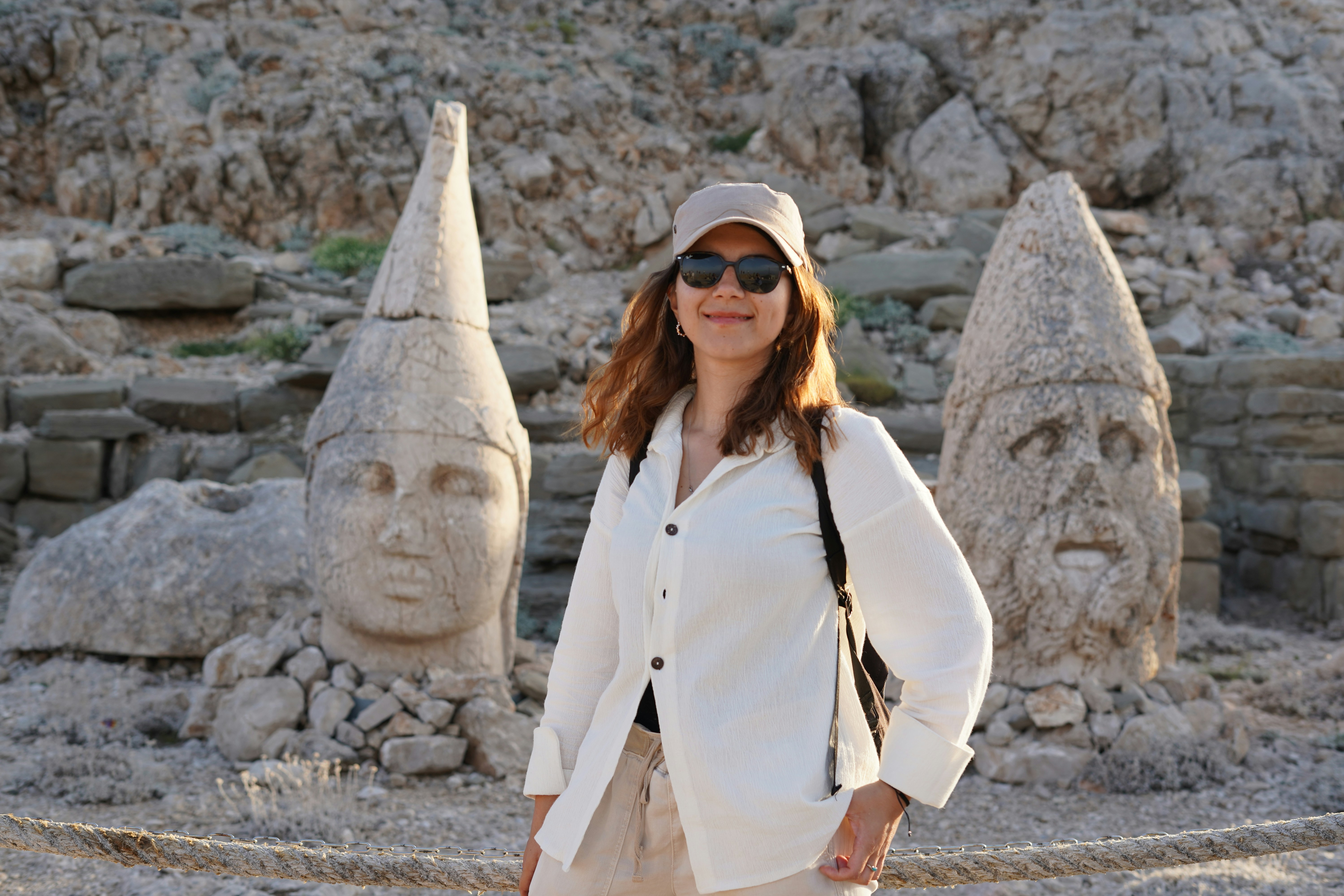 A woman standing in front of a stone sculpture