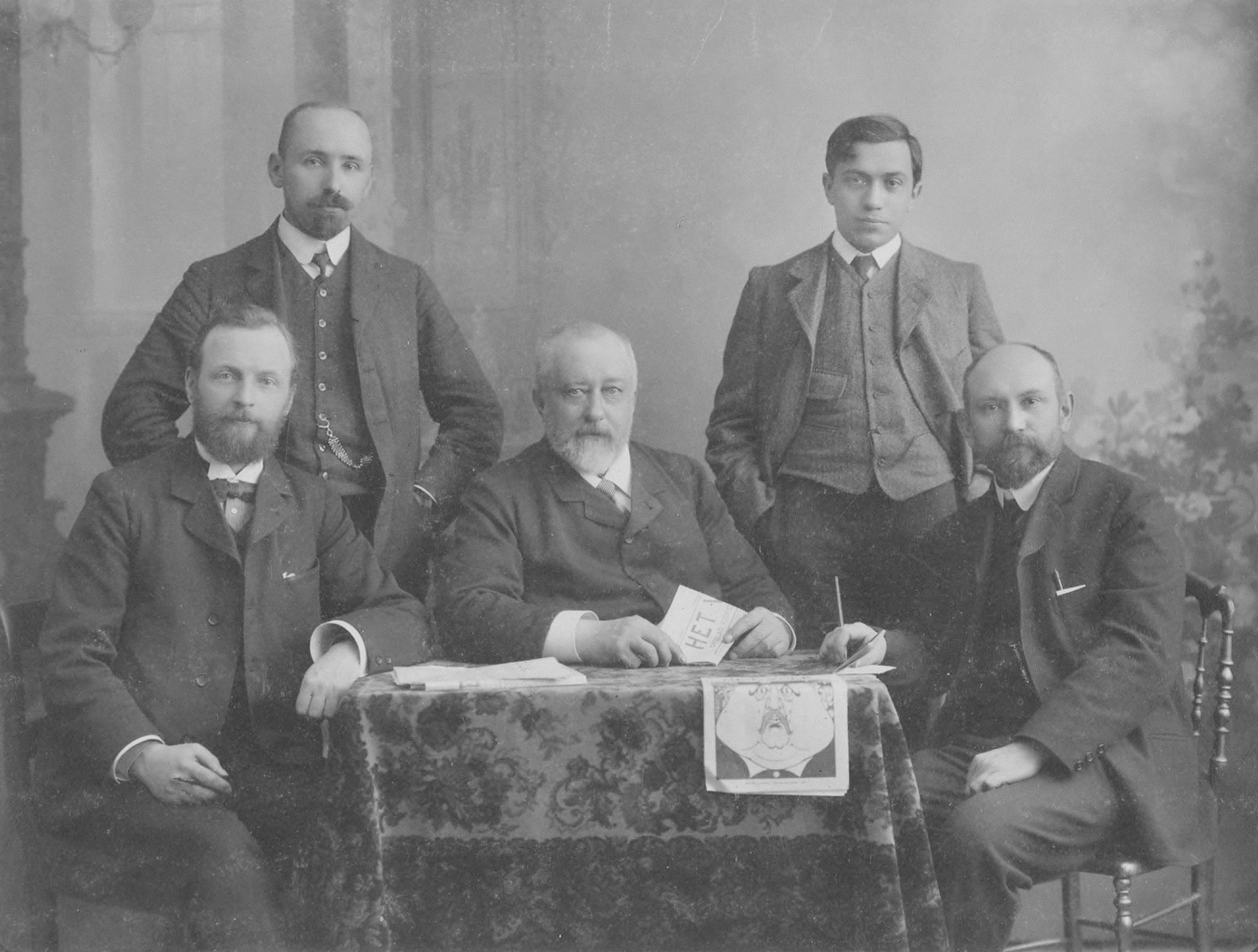Titel: Groepsportret van de leden van de redactie van dagblad Het Volk. Midden: hoofdredacteur Pieter Lodewijk Tak (1848-1907). Beschrijving: Links Jan de Roode en F. Ankersmit. Rechts Eduard Polak en Willem Hubertus Vliegen.