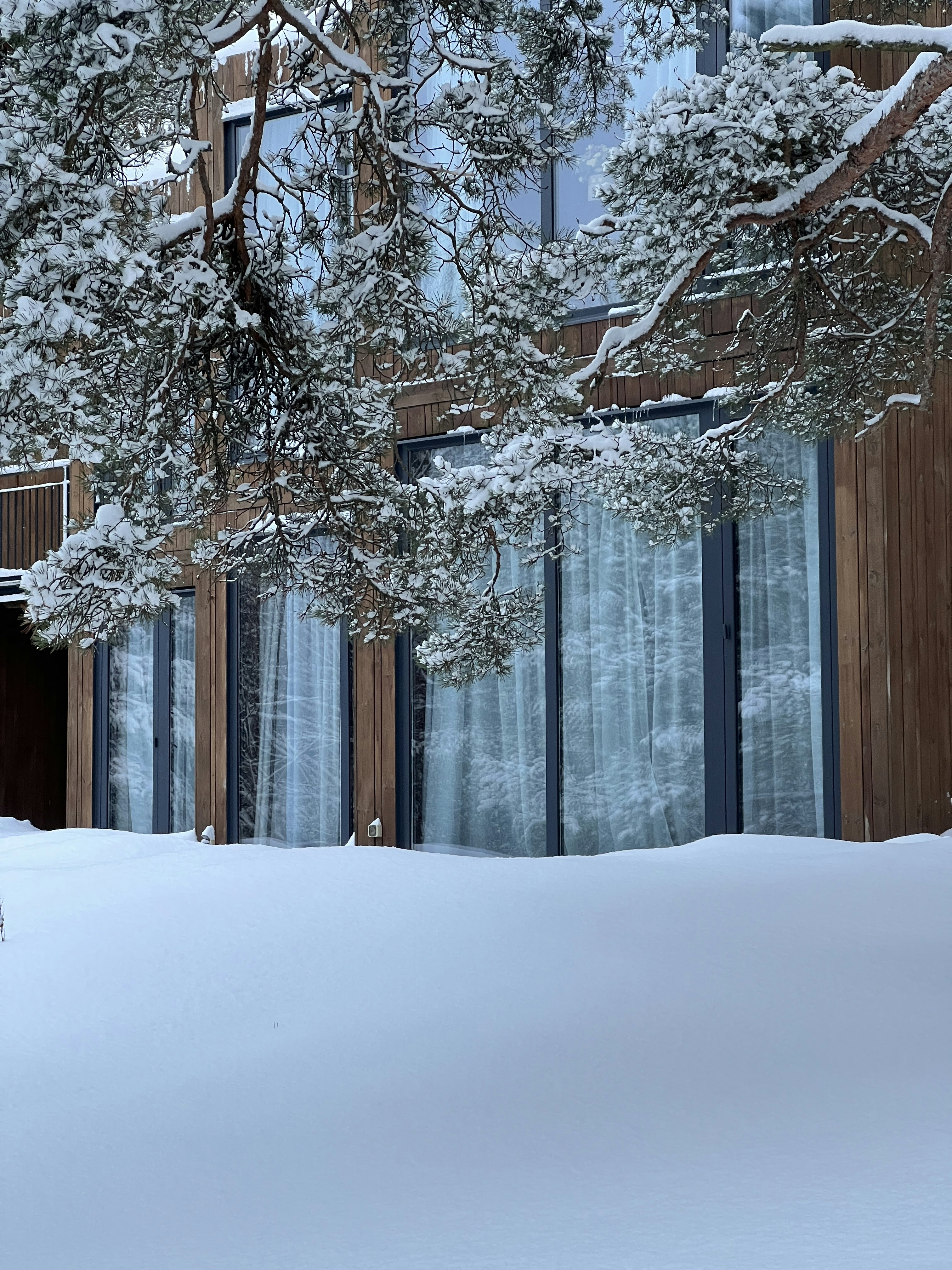 A snow covered street with a building in the background