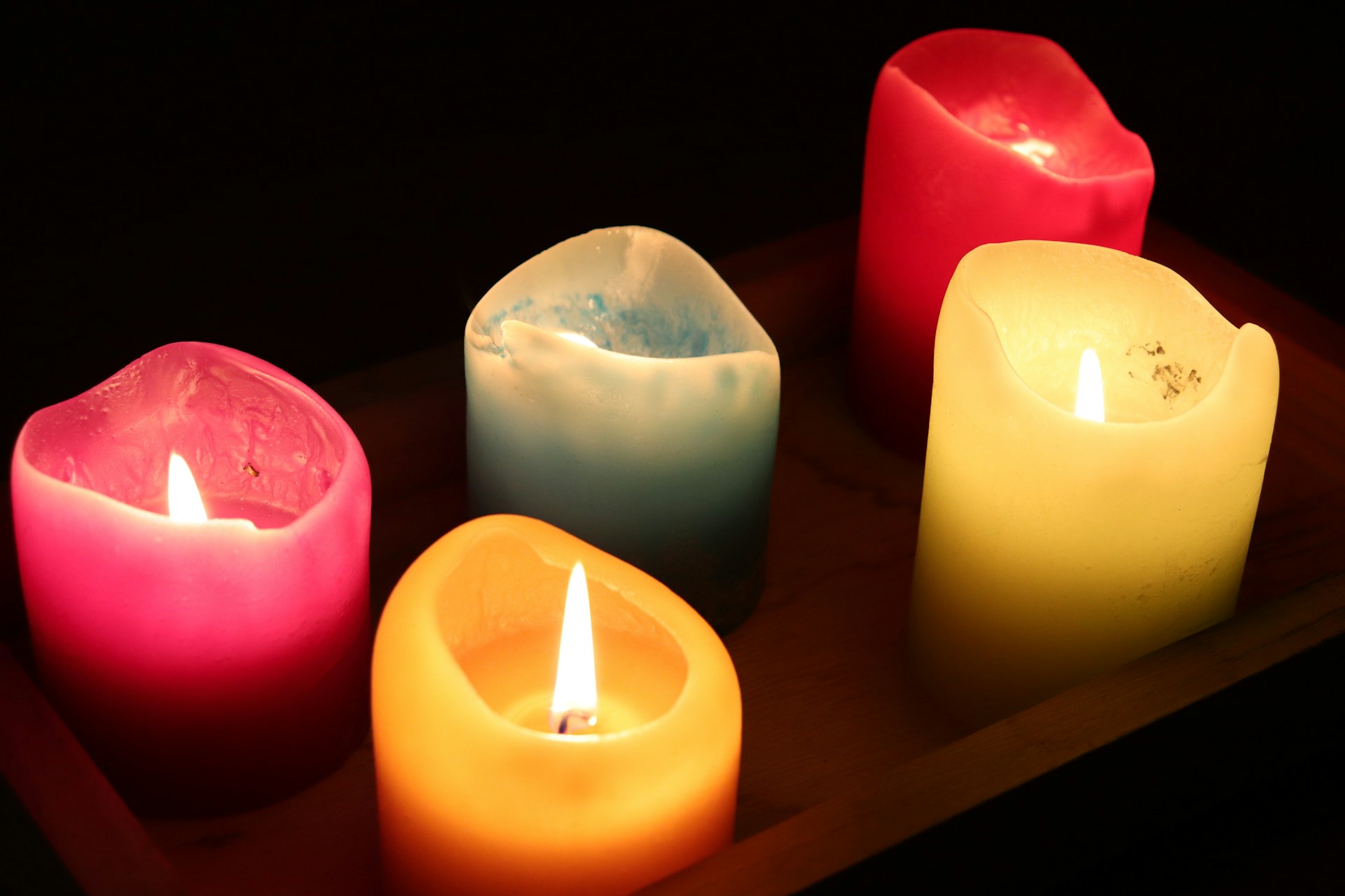 A group of lit candles sitting on top of a tray