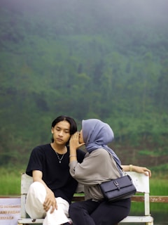 A couple of people sitting on a white bench
