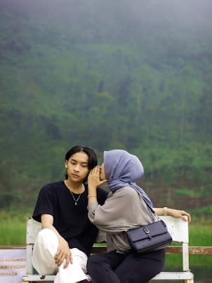 A couple of people sitting on a white bench
