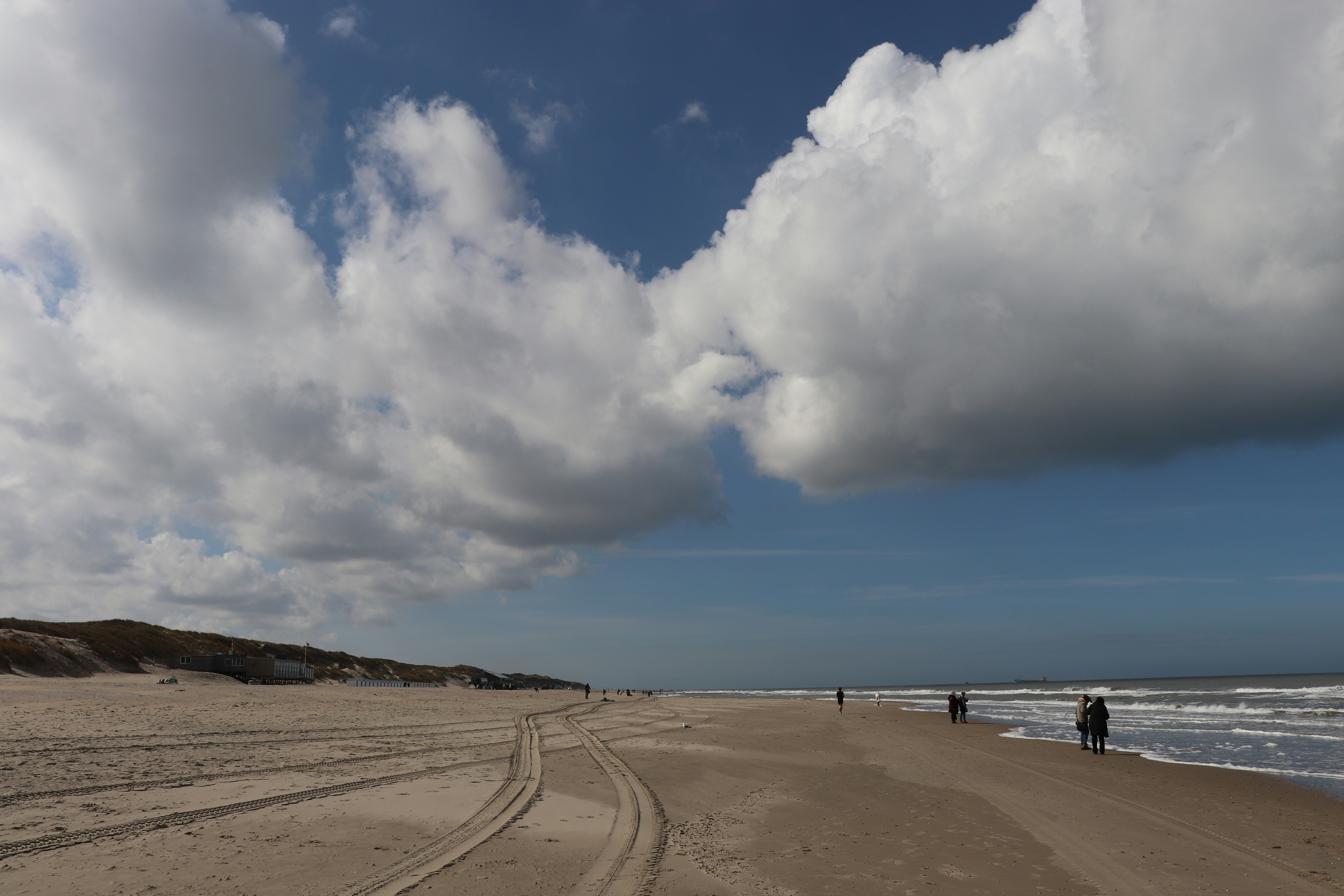 A sandy beach next to the ocean under a cloudy sky