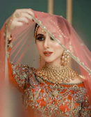 A woman in a red and gold bridal outfit