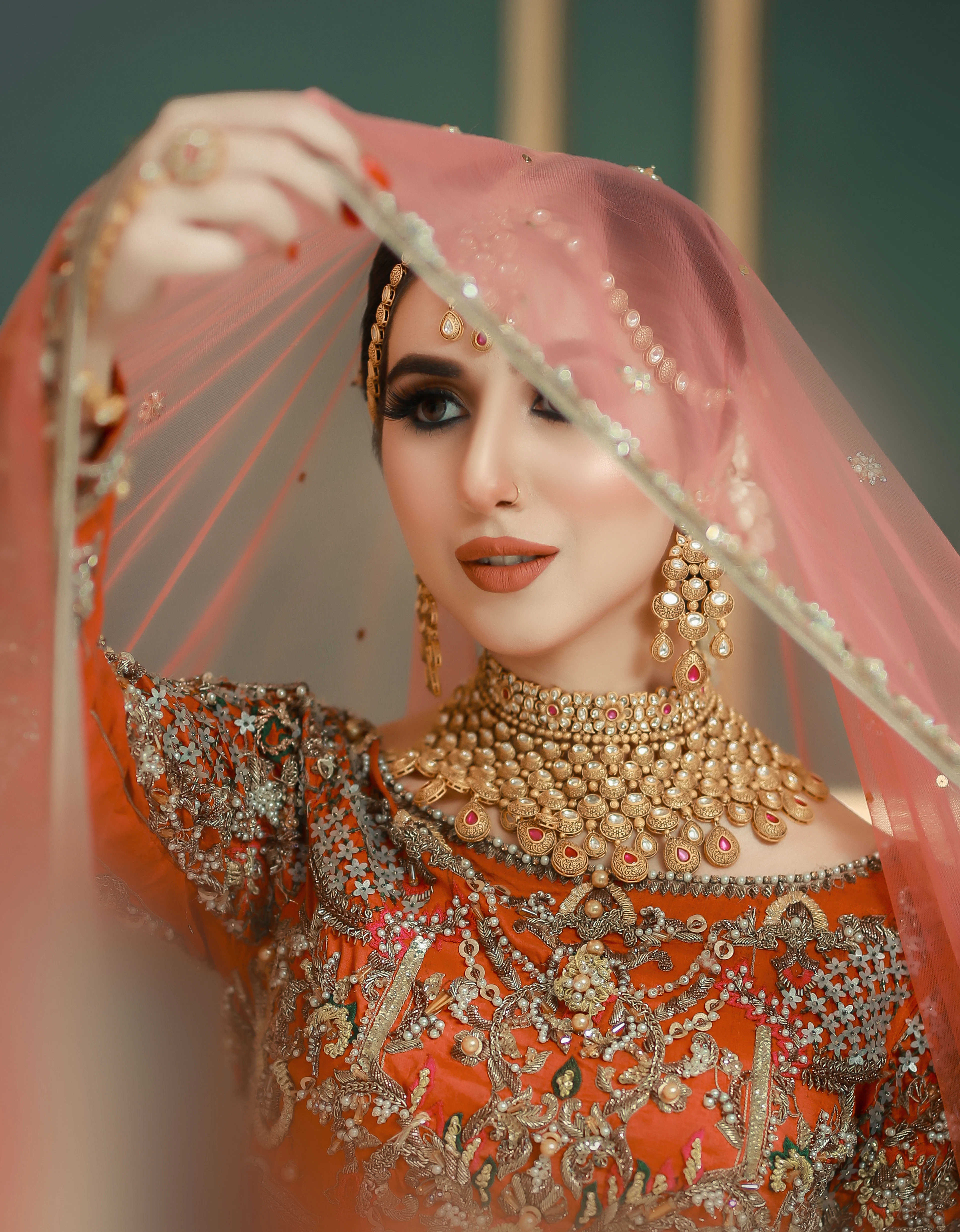 Bride lifting a sheer peach veil