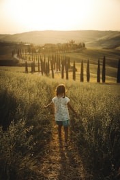 A little girl walking down a dirt road
