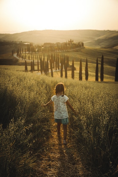 A little girl walking down a dirt road